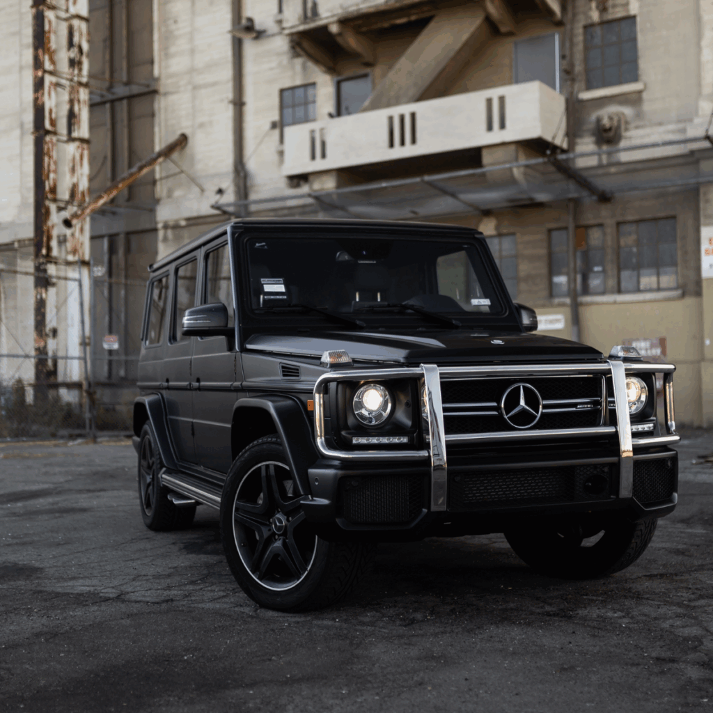 A black Mercedes truck parked in an industrial parking lot.